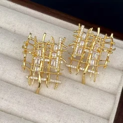 Ζευγάρι χρυσών καρφωτών σκουλαρικιών με αφηρημένο δικτυωτό ή πλεκτό σχέδιο, διακοσμημένα με λαμπερά κρύσταλλα Zircon σε κοπή μπαγκέτας και στρογγυλή. Σκουλαρίκια statement.