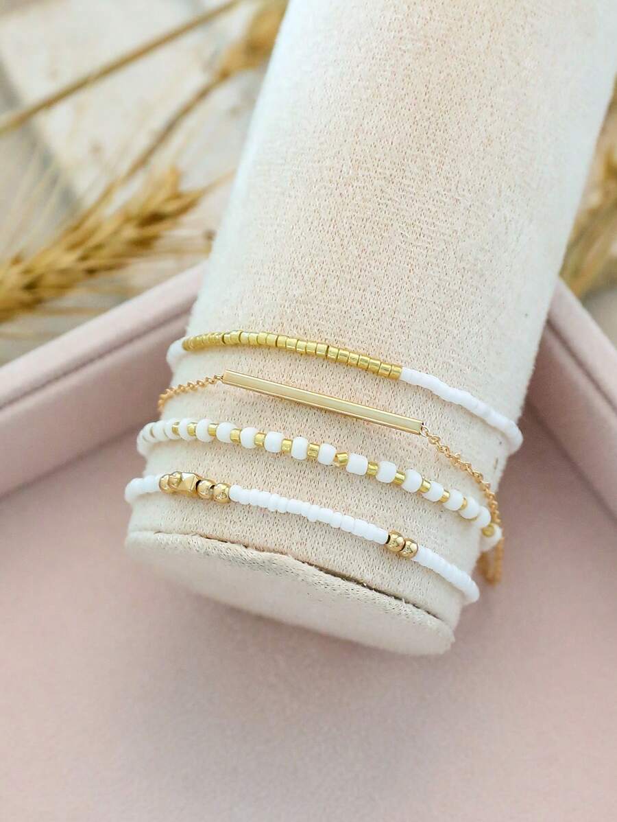 Σετ 4 Γυναικεία Βραχιόλια με Λευκές Χάντρες και Χρυσή Μπάρα