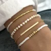 Σετ 4 Γυναικεία Βραχιόλια με Λευκές Χάντρες και Χρυσή Μπάρα