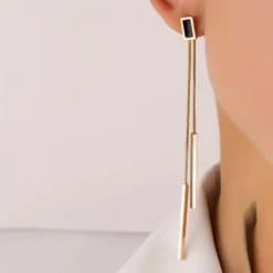 Γυναικεία μακριά σκουλαρίκια με χρυσές και ασημένιες μπάρες και μαύρη λεπτομέρεια σε minimal στυλ.