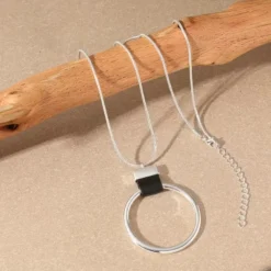 Γυναικείο μακρύ κολιέ με χρυσό γεωμετρικό κύκλο και δερμάτινη λεπτομέρεια