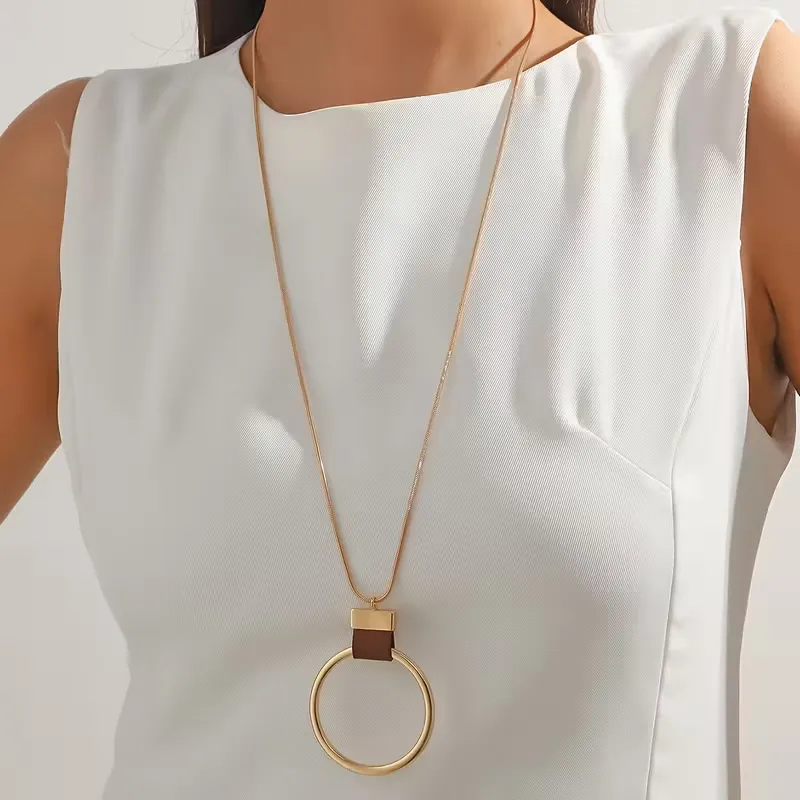 Γυναικείο μακρύ κολιέ με χρυσό γεωμετρικό κύκλο και δερμάτινη λεπτομέρεια