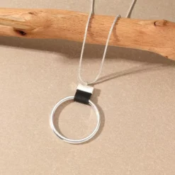 Γυναικείο μακρύ κολιέ με χρυσό γεωμετρικό κύκλο και δερμάτινη λεπτομέρεια