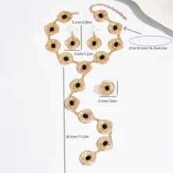 Γυναικείο σετ κοσμημάτων με χρυσό κολιέ, σκουλαρίκια και δαχτυλίδι με μαύρες πέτρες.