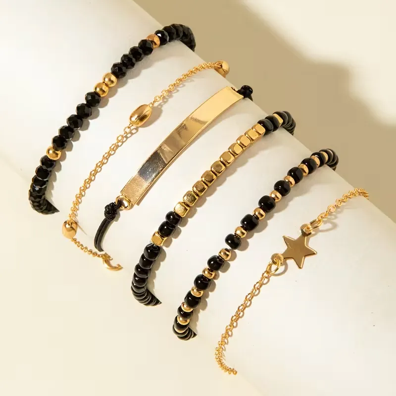 Γυναικείο σετ βραχιόλια 6 τεμαχίων με μαύρες χάντρες, χρυσές αλυσίδες και charm αστέρι.