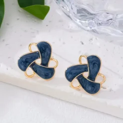 Γυναικεία σκουλαρίκια καρφωτά με μπλε σμάλτο και χρυσό πλαίσιο σε σχήμα κόμπου.