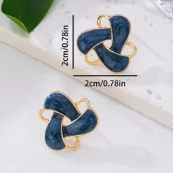 Γυναικεία σκουλαρίκια καρφωτά με μπλε σμάλτο και χρυσό πλαίσιο σε σχήμα κόμπου.