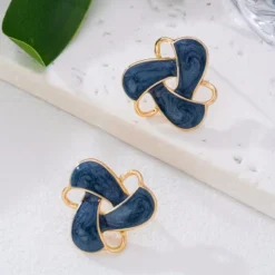 Γυναικεία σκουλαρίκια καρφωτά με μπλε σμάλτο και χρυσό πλαίσιο σε σχήμα κόμπου.
