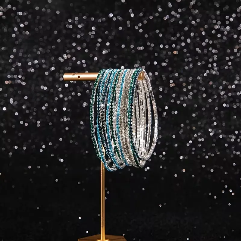 Πολλαπλά ελαστικά βραχιόλια ριβιέρα με πολύχρωμα ζιργκόν φορεμένα στον καρπό για layering.