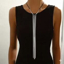 Μακρύ γυναικείο κολιέ με τέσσερις χρυσές αλυσίδες φίδι και μαύρο κορδόνι σε μαύρο φόρεμα.