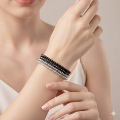 Σετ τεσσάρων ελαστικών βραχιολιών με μαύρες και ασημί κρυστάλλινες χάντρες σε λευκό φόντο.