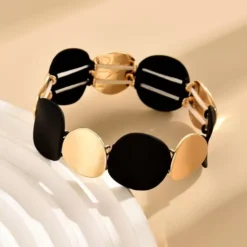 Αποκτήστε το πιο κομψό ελαστικό γυναικείο βραχιόλι με χρυσούς και μαύρους δίσκους. Μοντέρνο design και άνετη εφαρμογή για κάθε περίσταση. Δωρεάν αποστολή!