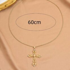 κολιέ με χρυσό σταυρό και λεπτομέρειες από νεκροκεφαλές σε μαύρο φόντο.