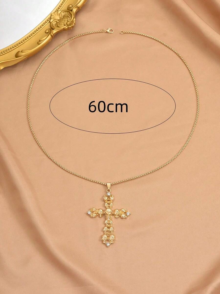 κολιέ με χρυσό σταυρό και λεπτομέρειες από νεκροκεφαλές σε μαύρο φόντο.