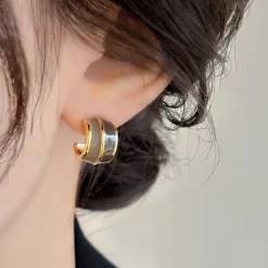 Γυναικεία χρυσά σκουλαρίκια κρίκοι με δίχρωμο σμάλτο σε καφέ και μπεζ αποχρώσεις.