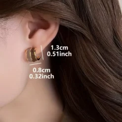 Γυναικεία χρυσά σκουλαρίκια κρίκοι με δίχρωμο σμάλτο σε καφέ και μπεζ αποχρώσεις.