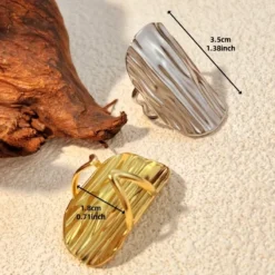 Μακρύ γυναικείο δαχτυλίδι από ανοξείδωτο ατσάλι σε χρυσό και ασημί χρώμα με ανάγλυφο κυματιστό σχέδιο.