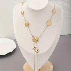 Μακρύ γυναικείο κολιέ σε χρυσό χρώμα με κυκλικούς δίσκους lariat στυλ.