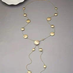 Μακρύ γυναικείο κολιέ σε χρυσό χρώμα με κυκλικούς δίσκους lariat στυλ.