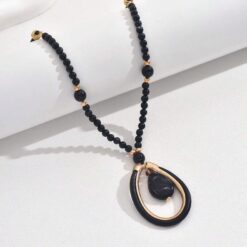 Γυναικείο μακρύ κολιέ boho με μαύρες χάντρες και χρυσό οβάλ μενταγιόν