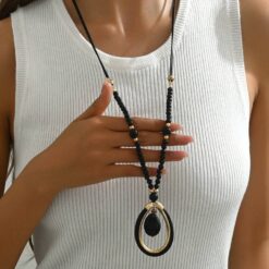 Γυναικείο μακρύ κολιέ boho με μαύρες χάντρες και χρυσό οβάλ μενταγιόν