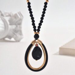 Γυναικείο μακρύ κολιέ boho με μαύρες χάντρες και χρυσό οβάλ μενταγιόν