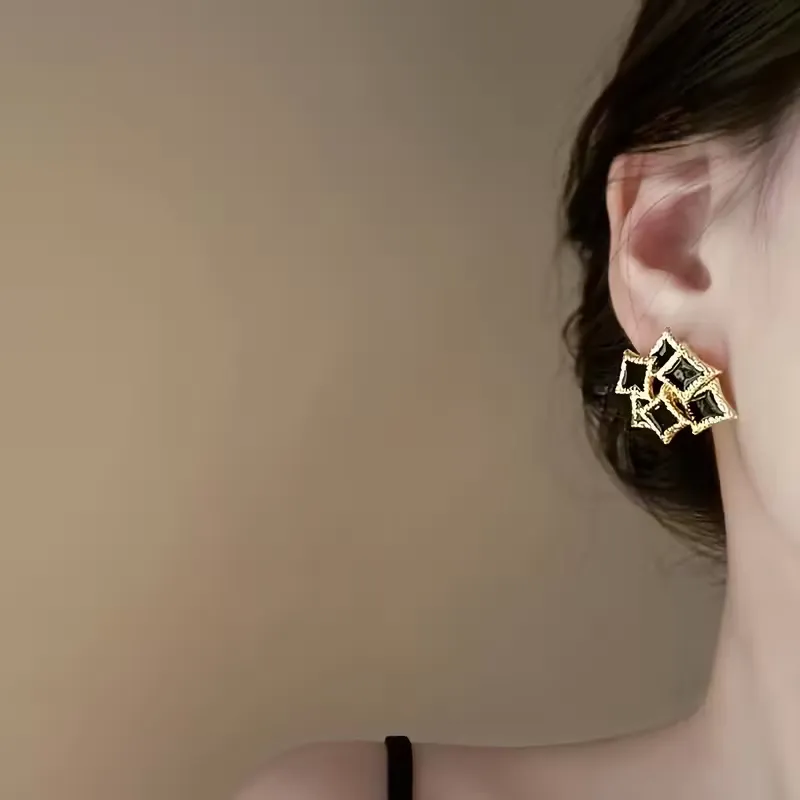 Vintage γυναικεία σκουλαρίκια με μαύρο σμάλτο και ανάγλυφο χρυσό πλαίσιο.