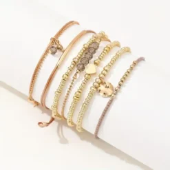 Γυναικείο σετ με 7 boho βραχιόλια σε χρυσό χρώμα με καρδιά και κρύσταλλα.