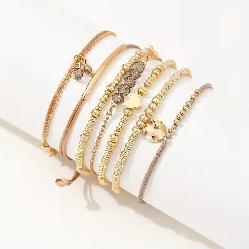 Γυναικείο σετ με 7 boho βραχιόλια σε χρυσό χρώμα με καρδιά και κρύσταλλα.