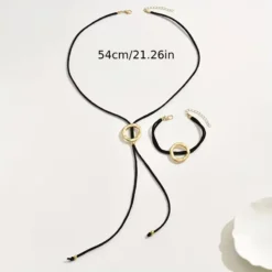 Γυναικείο σετ κολιέ λάσο και βραχιόλι με μαύρο κορδόνι και σφυρήλατους χρυσούς κύκλους.
