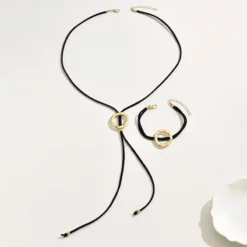 Γυναικείο σετ κολιέ λάσο και βραχιόλι με μαύρο κορδόνι και σφυρήλατους χρυσούς κύκλους.