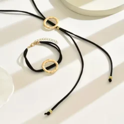 Γυναικείο σετ κολιέ λάσο και βραχιόλι με μαύρο κορδόνι και σφυρήλατους χρυσούς κύκλους.