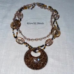 Μακρύ γυναικείο boho κολιέ με μεγάλο leopard μενταγιόν και χάντρες σε καφέ χρώμα.