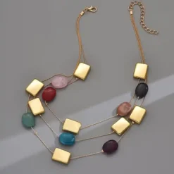 Γυναικείο τριπλό κολιέ layered με πολύχρωμες πέτρες και χρυσά γεωμετρικά στοιχεία.