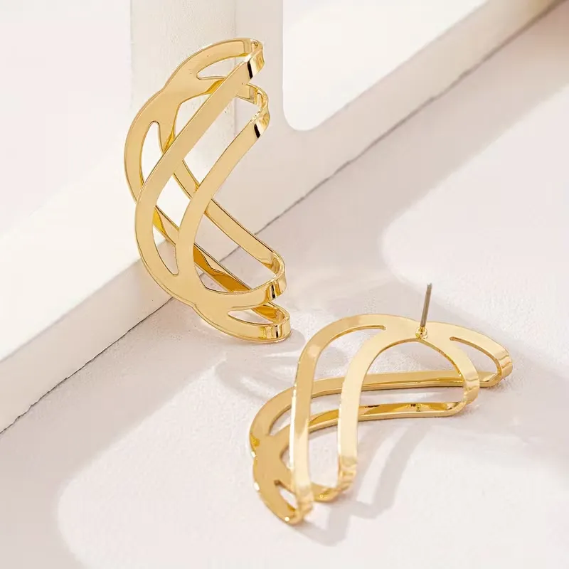 Γυναικεία χρυσά γεωμετρικά σκουλαρίκια σε abstract wave σχέδιο.