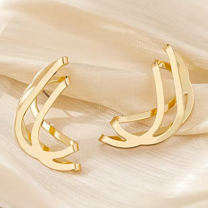 Γυναικεία χρυσά γεωμετρικά σκουλαρίκια σε abstract wave σχέδιο.