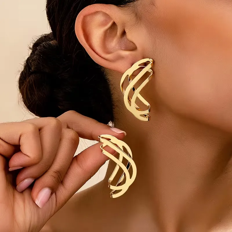 Γυναικεία χρυσά γεωμετρικά σκουλαρίκια σε abstract wave σχέδιο.