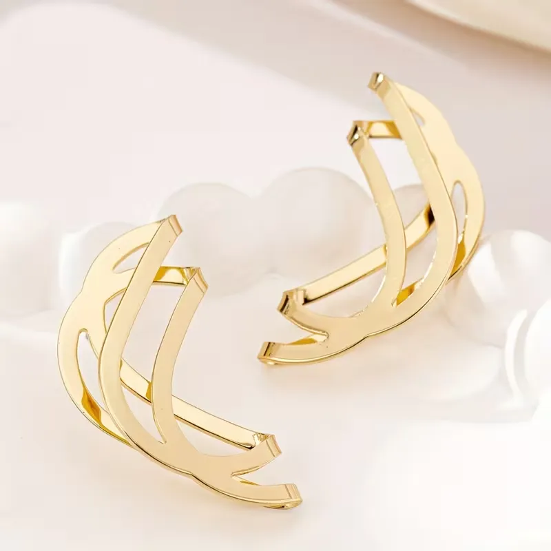 Γυναικεία χρυσά γεωμετρικά σκουλαρίκια σε abstract wave σχέδιο.