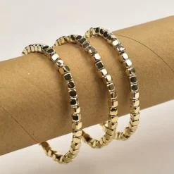 Σετ τρία γυναικεία ελαστικά βραχιόλια με μικρούς χρυσούς και ασημένιους μεταλλικούς κύβους