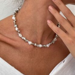 Γυναικείο κολιέ με λευκά μαργαριτάρια baroque και ασημί ακανόνιστες χάντρες σε λαιμό μοντέλου.