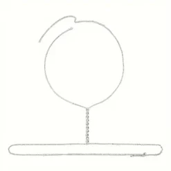 Γυναικείο κόσμημα σώματος body chain σε ασημί χρώμα με σειρά από κρυστάλλινες καρδιές φορεμένο με λευκό σακάκι και μαγιό.