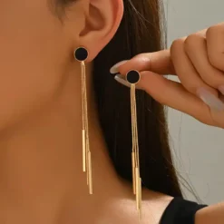 Ζευγάρι μακριά χρυσά γυναικεία σκουλαρίκια με μαύρο κυκλικό στοιχείο και κρεμαστές αλυσίδες