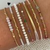 Σετ από επτά γυναικεία βραχιόλια σε boho στυλ με πολύχρωμες χάντρες, χρυσές αλυσίδες και λευκό κορδόνι