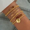 Γυναικείος καρπός με σετ έξι χρυσά boho βραχιόλια με στοιχεία καρδιάς και φλουριού Chicbee